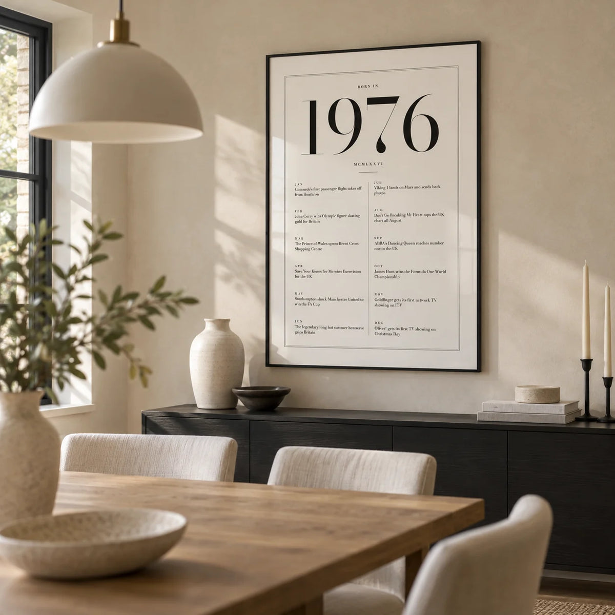 1976 Birthday Print, framed on the wall of a modern dining room in a British family home with a pale stone wall and an oak dining table