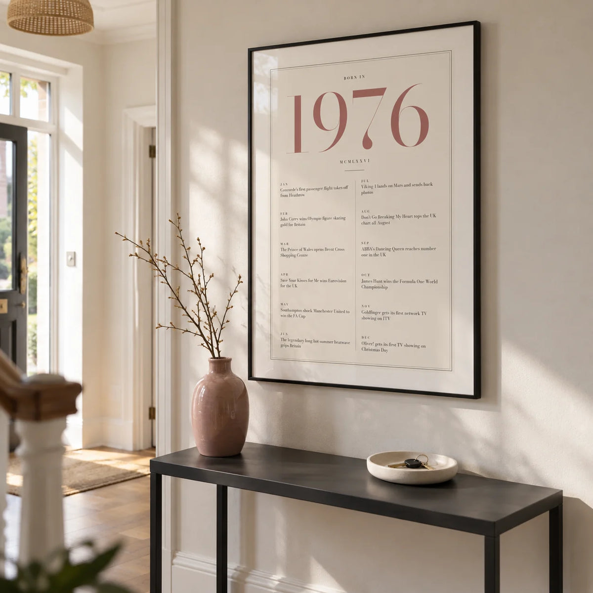 1976 Pink Birthday Print, framed on the wall of a bright entrance hallway in a renovated UK semi with warm white walls and oak floorboards