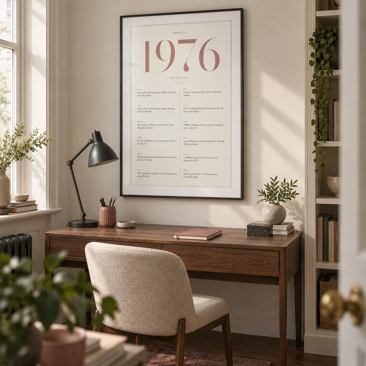 1976 Pink Birthday Print, framed on the wall of a compact grown-up home study in a UK townhouse with warm white walls and a walnut floor