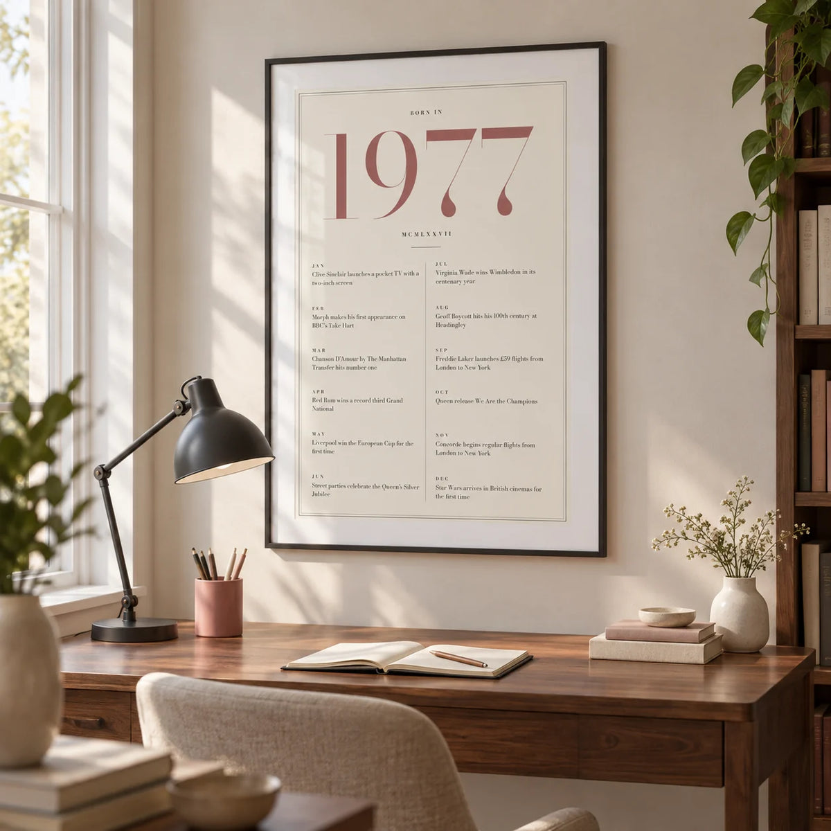1977 Pink Birthday Print, framed on the wall of a bright home study for an adult born in 1977 with an ivory wall and a simple walnut desk