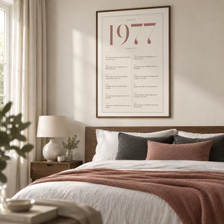 1977 Pink Birthday Print, framed on the wall of a contemporary main bedroom in a UK home with an ivory wall and plain full-length curtains