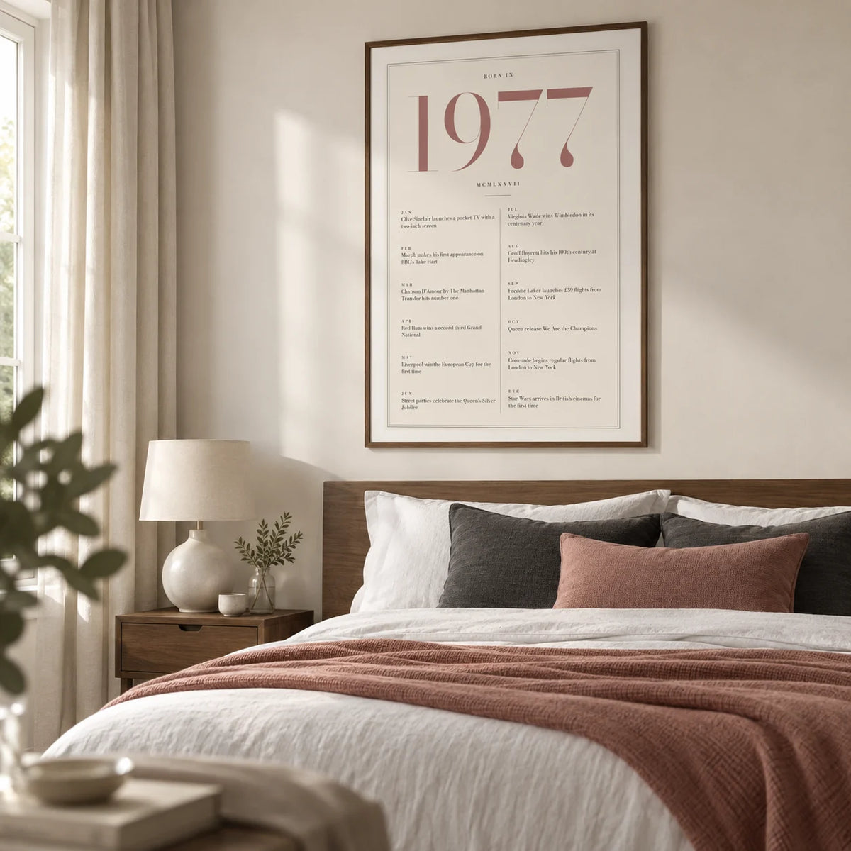 1977 Pink Birthday Print, framed on the wall of a contemporary main bedroom in a UK home with an ivory wall and plain full-length curtains