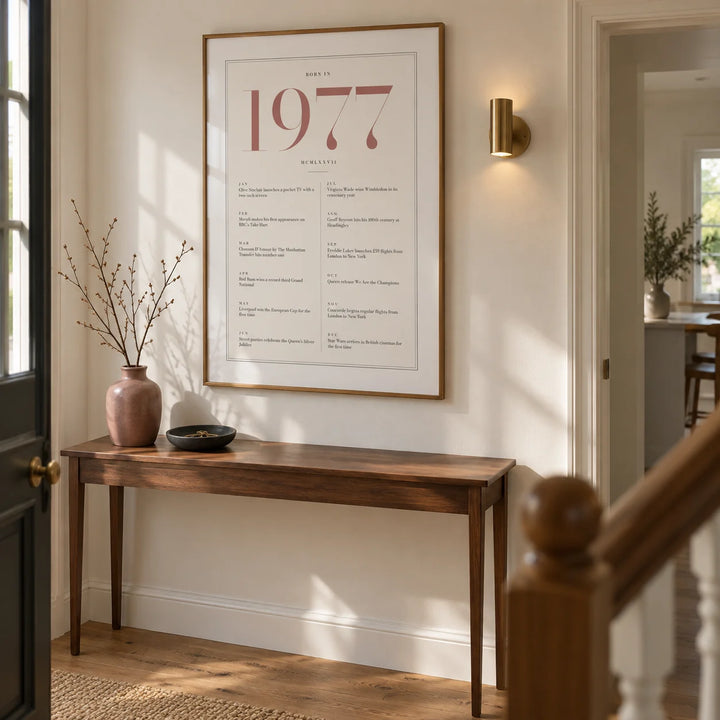 1977 Pink Birthday Print, framed on the wall of a welcoming hallway in a renovated British semi-detached house with warm white walls and oak floorboards