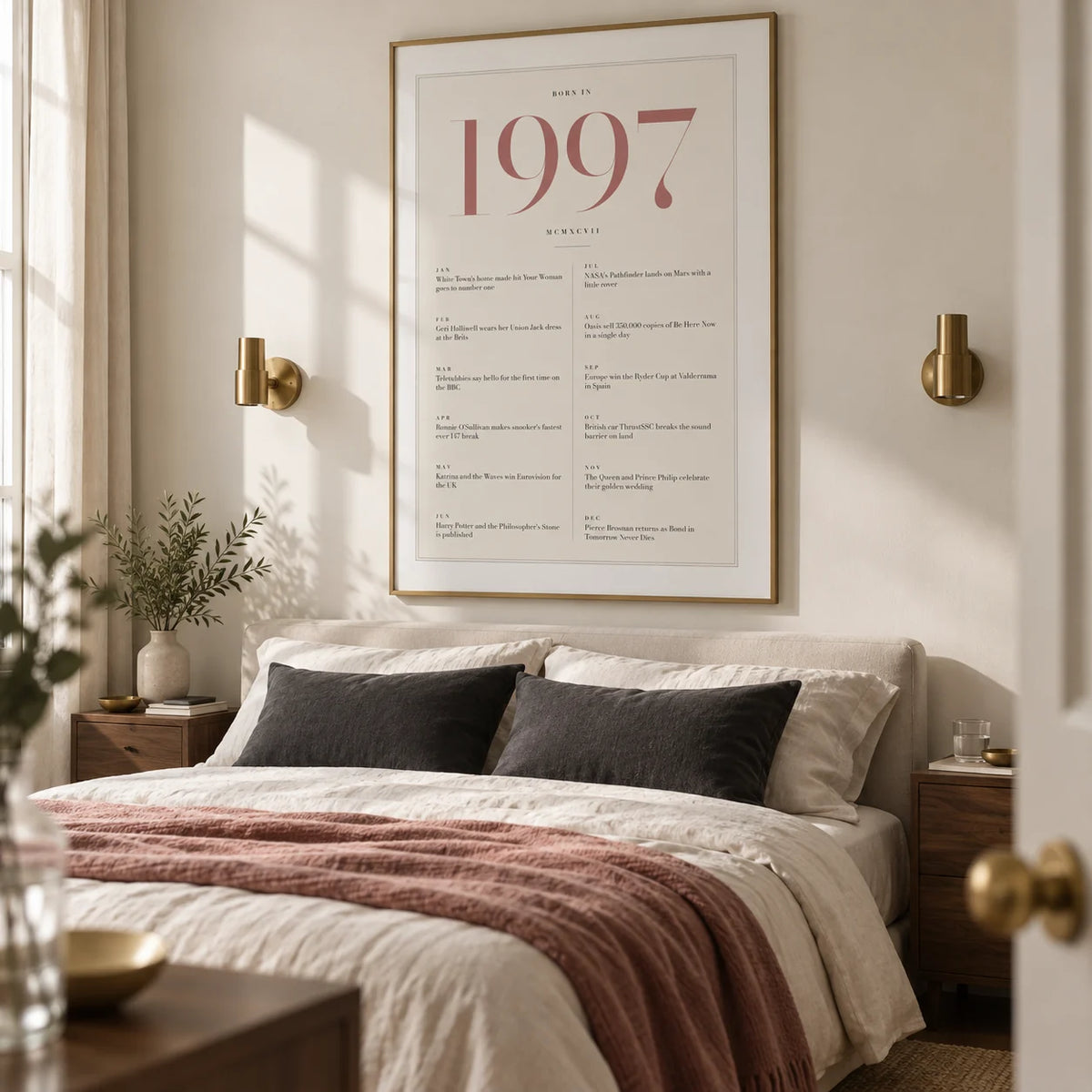 1997 Pink Birthday Print, framed on the wall of a refined adult bedroom in a UK flat with an ivory wall and simple brass wall lights