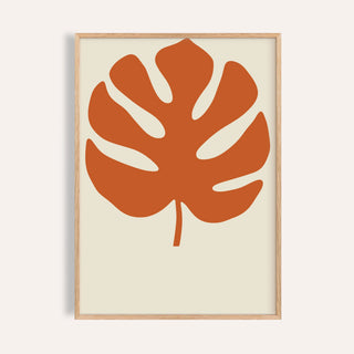 Monstera print in burnt orange shown on a plain warm wall