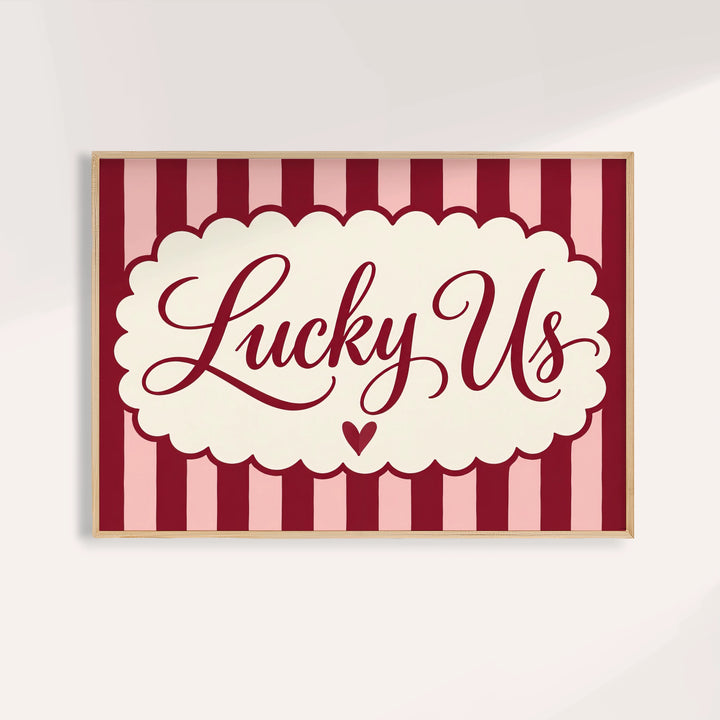 Above bed wall art with Lucky Us in burgundy script on pink and burgundy stripes