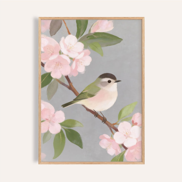 Small green and white songbird perched among pink blossom branches on a grey ground