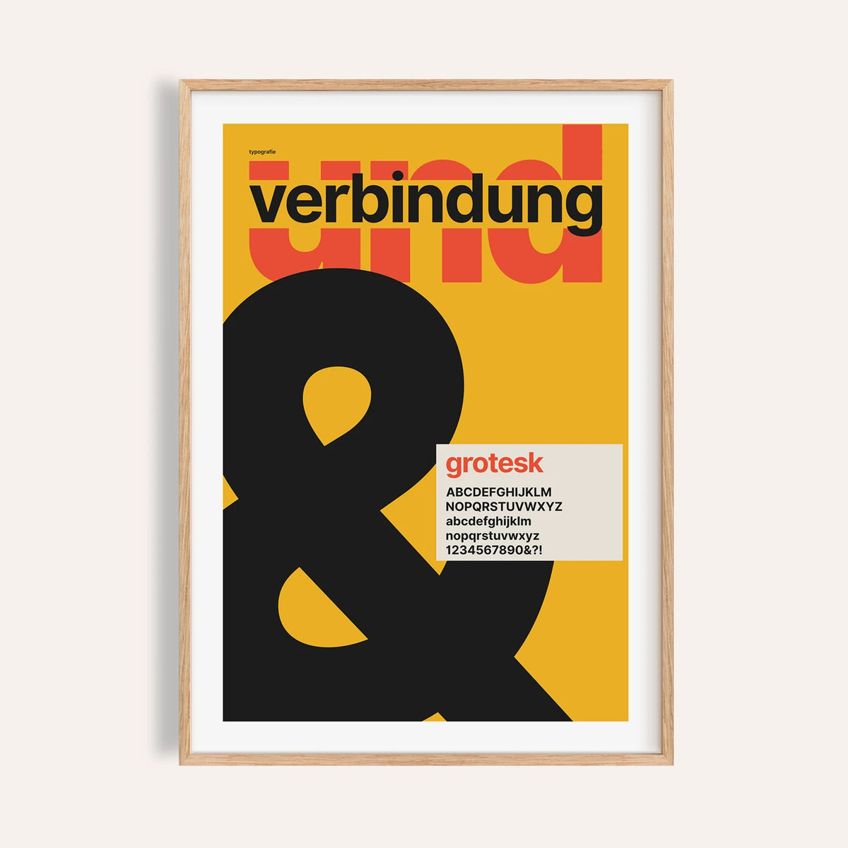 Giant black ampersand print shown on a plain warm wall