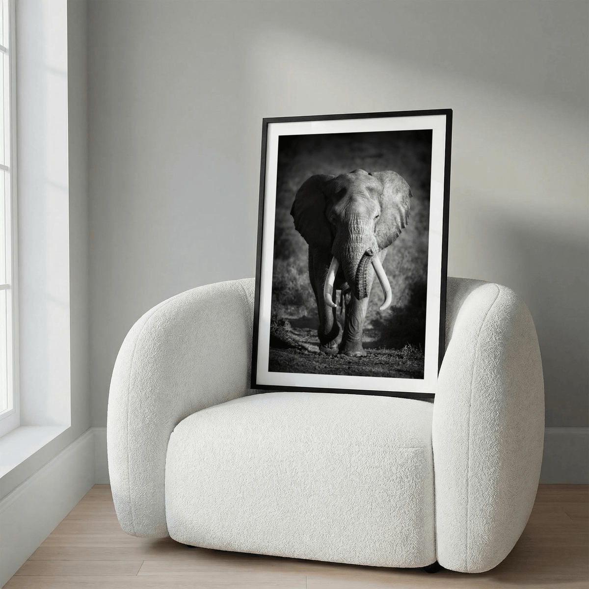 Side-angle print of elephant walking forward on earthy terrain