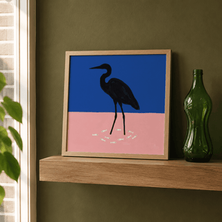 Framed bird silhouette artwork resting on wooden shelf