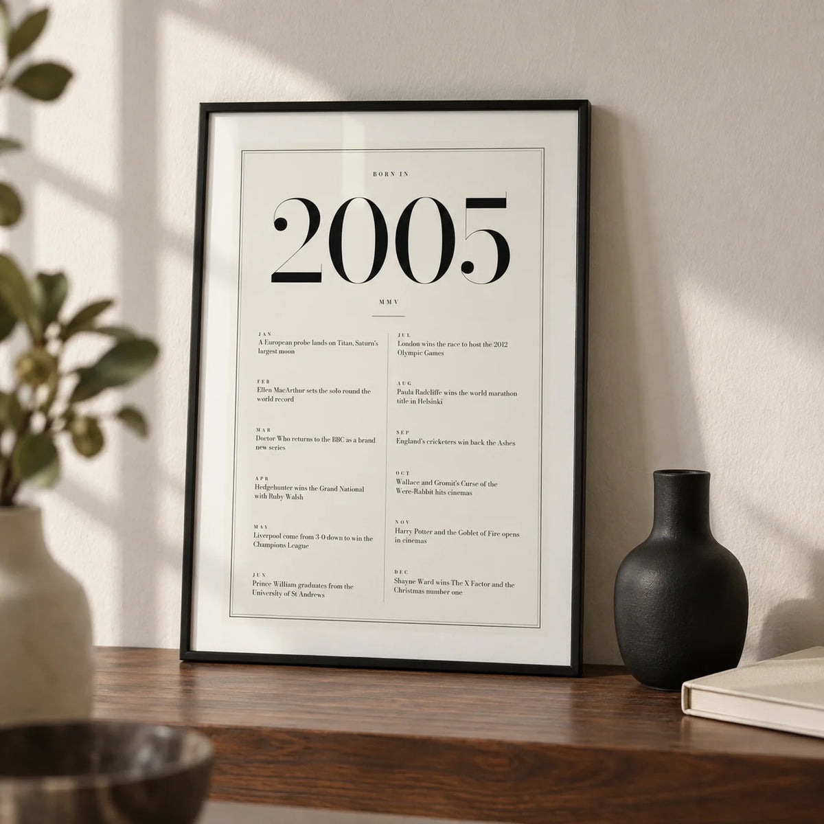 2005 Birthday Print, a small A4 framed print leaning on a walnut shelf in a living room