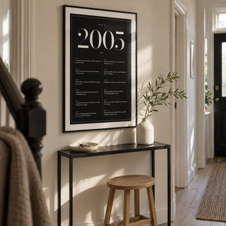 2005 Black Birthday Print, framed on the wall of a narrow hallway in a modern UK terraced home with a warm white wall and pale timber floor