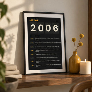 2006 Arrivals Board Print, a small A4 framed print leaning on a walnut shelf in a living room