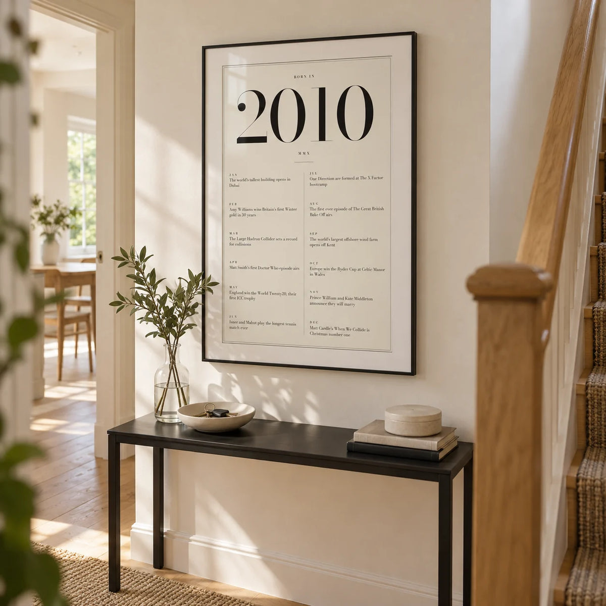 2010 Birthday Print, framed on the wall of a bright hallway in a renovated UK terraced family home with warm white plaster walls and oak floorboards