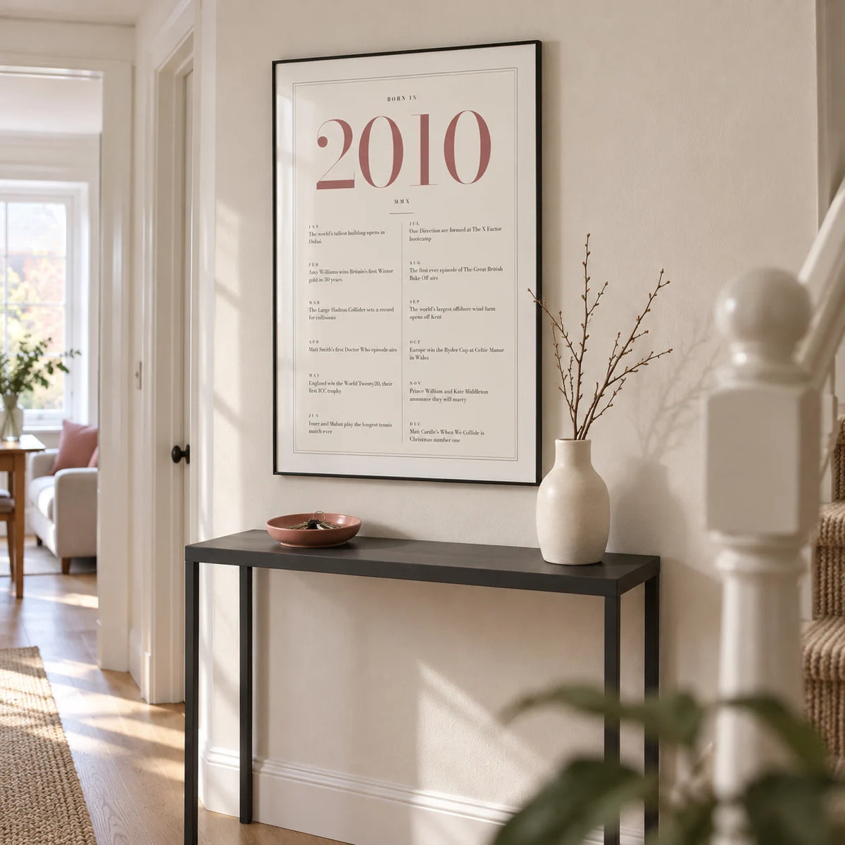 2010 Pink Birthday Print, framed on the wall of a light hallway in a modern UK terraced family home with a warm white wall and pale oak floor
