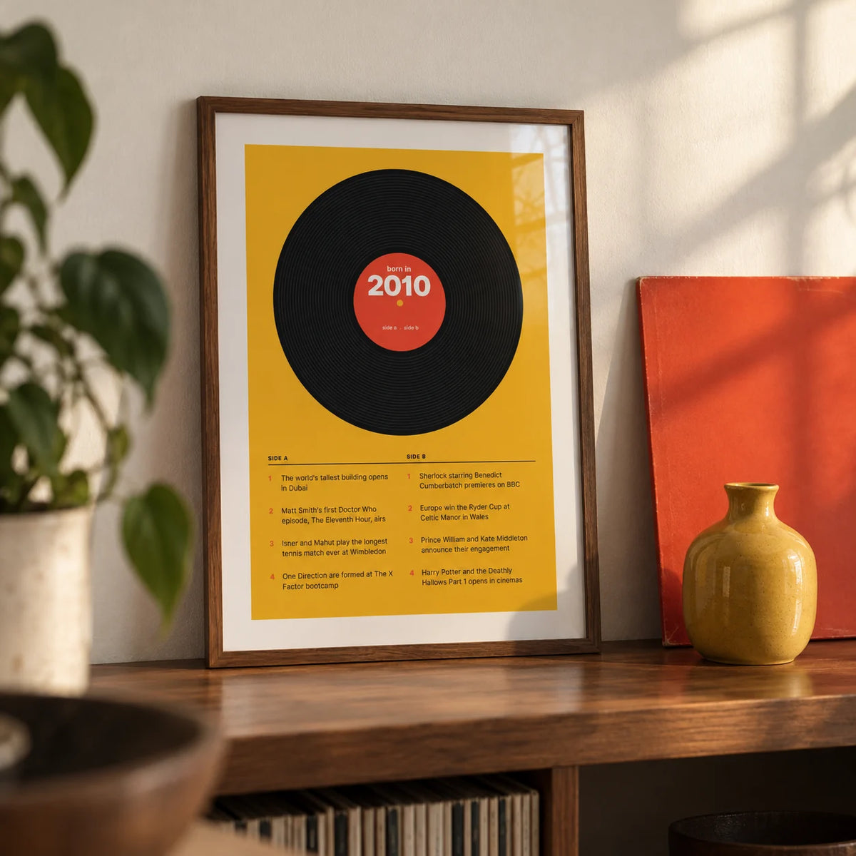 2010 Vinyl Record Print, a small A4 framed print leaning on a walnut shelf in a living room