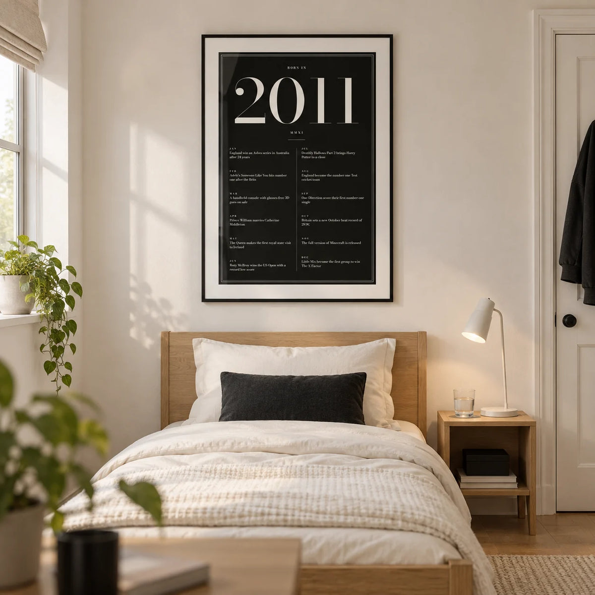 2011 Black Birthday Print, framed on the wall of a modern teen bedroom (14-16) in a UK family home with a warm white wall and pale oak floor