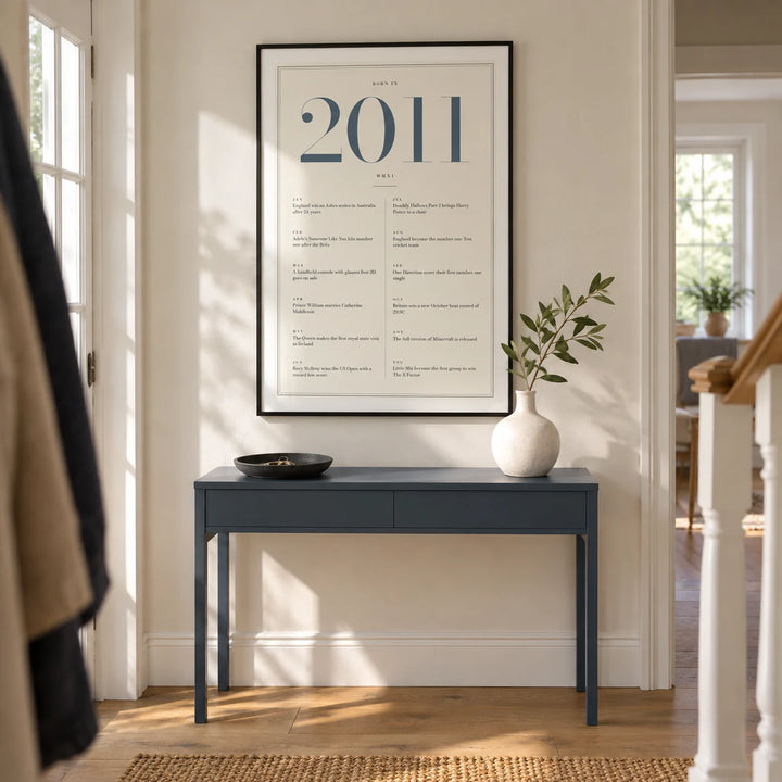 2011 Blue Birthday Print, framed on the wall of a bright entrance hallway in a modern UK family house with a pale cream wall and simple oak flooring