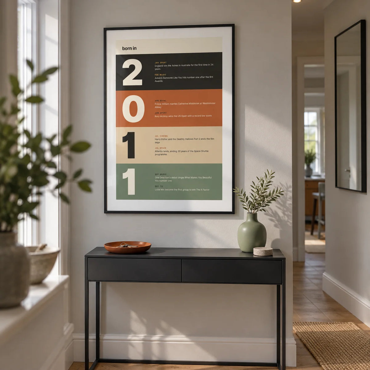 2011 Typography Print, framed on the wall of a compact contemporary hallway in a UK family home with pale grey walls and oak floorboards
