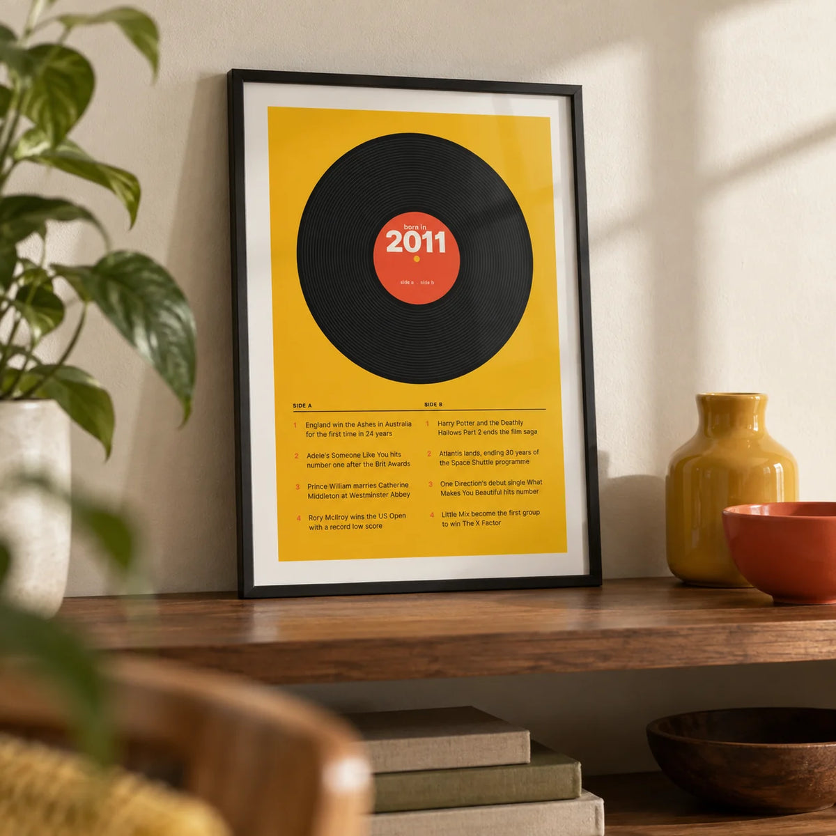 2011 Vinyl Record Print, a small A4 framed print leaning on a walnut shelf in a living room