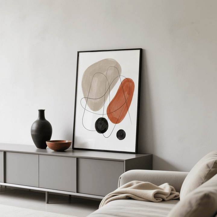 Abstract Shapes Art Print leaning on a grey sideboard with a black vase and bowl in a living room