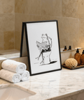 Sketch-style print featuring a frog seated on a toilet, central motif with wide white space