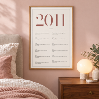 Cream and dusty rose 2011 birth year print on a wall in a lived in room