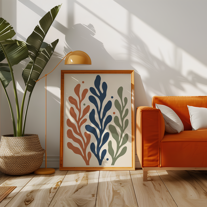 Rust, navy and sage frond print beside an orange sofa in a sunny living room