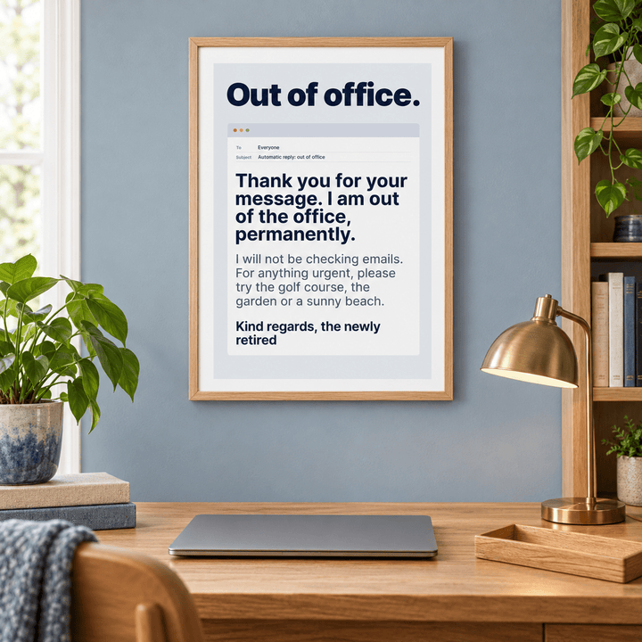 Funny out of office retirement print above a cleared desk in a home office