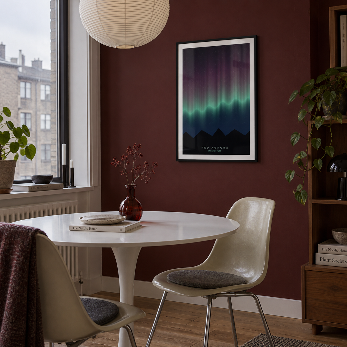 Rare red aurora over mountains print in a dining nook against an oxblood wall