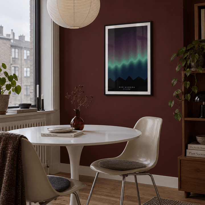 Rare red aurora over mountains print in a dining nook against an oxblood wall