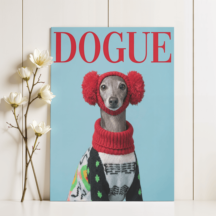 Print leaning on a shelf with white flowers beside it of a greyhound dog with red earmuffs and a patterned jumper