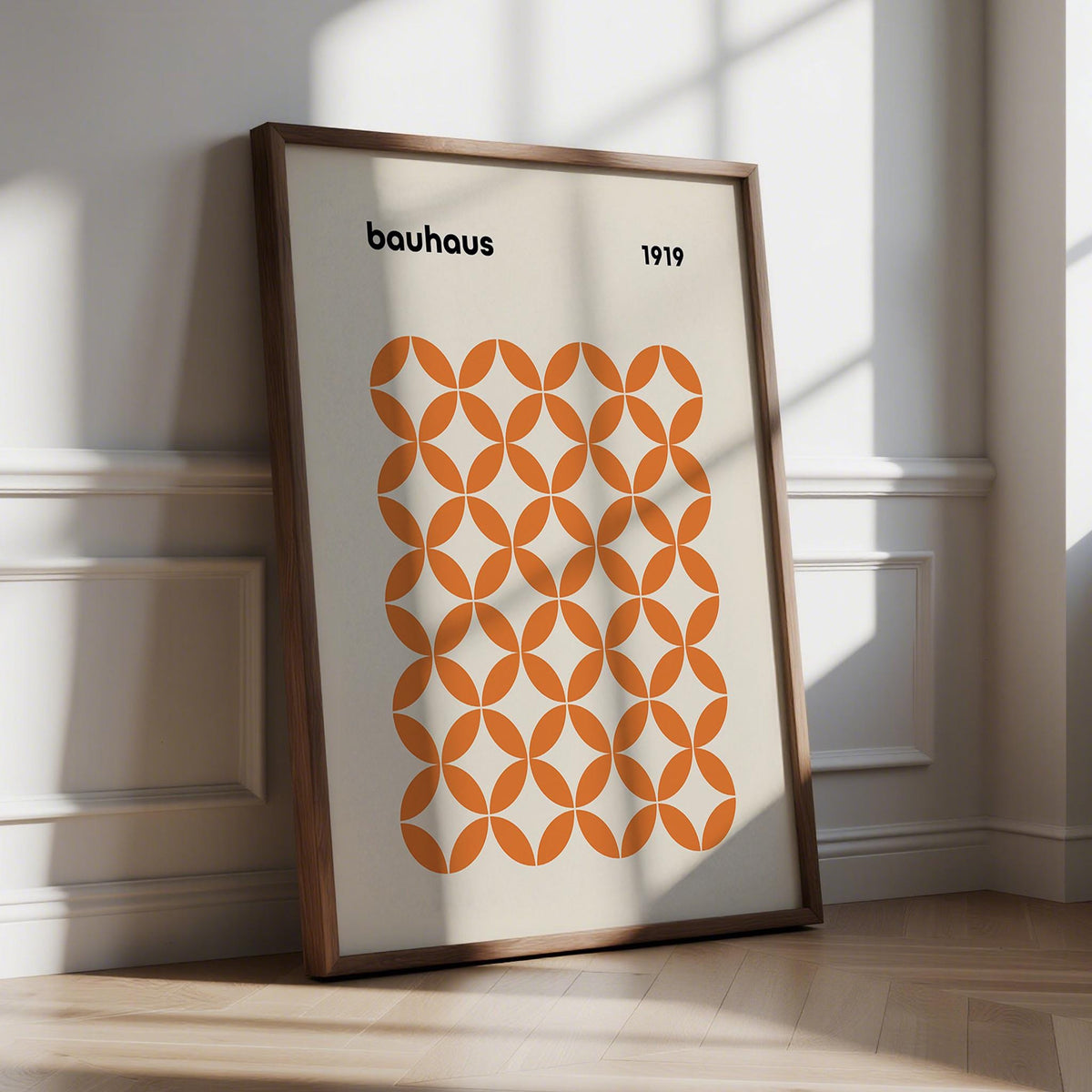 Orange minimalist print with intersecting circle pattern in bold Bauhaus style.