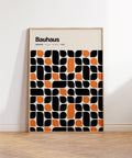Black and orange artwork with Bauhaus pattern set on cream background.