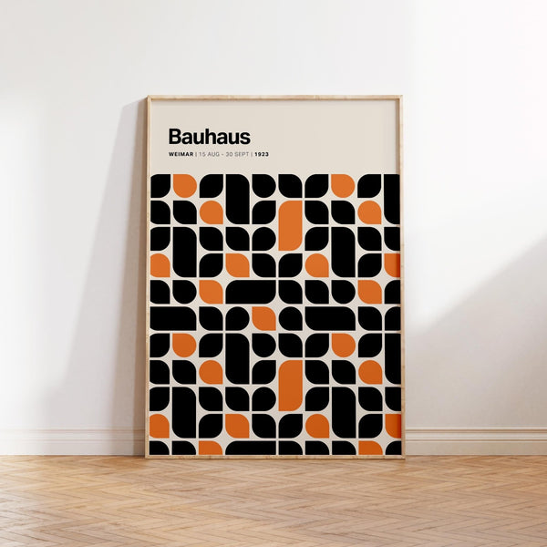 Black and orange artwork with Bauhaus pattern set on cream background.