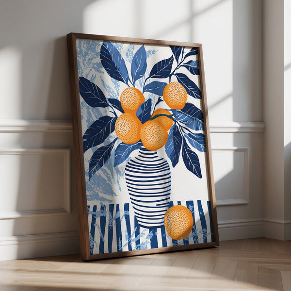 Close-up of orange blue wall art with citrus branches and navy leaves in striped vase.