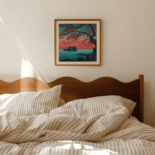 Overhead angle of Hasui Kawase sunset seascape print on wooden desk