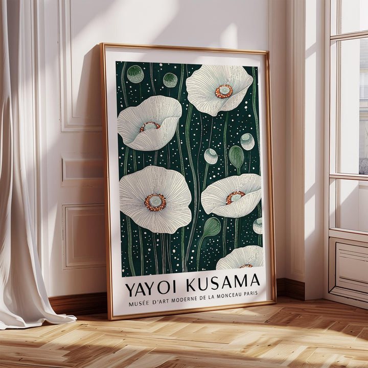 Poppy wall art with white poppy flowers and green stems leaning on a floor by a sunny window