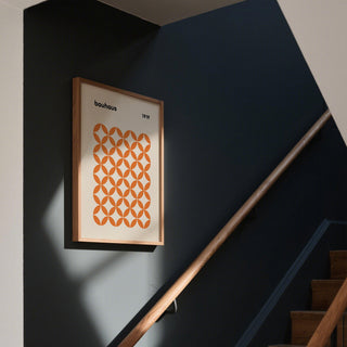 Abstract orange minimalist print featuring geometric repetition on neutral background.