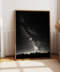 Monochrome astronomy wall art print with dense star field and bright galactic core over peaks