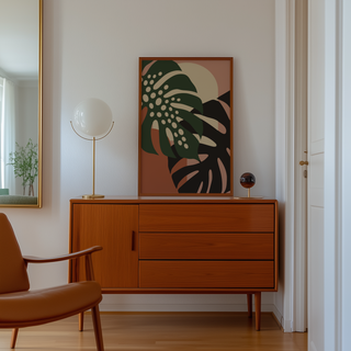 Cut paper leaves on blush and terracotta above a mid century sideboard in a hallway