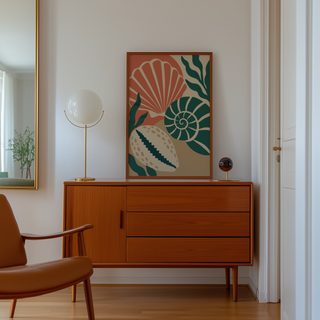 Cut paper cowrie shell and seaweed print above a mid century sideboard in a hallway