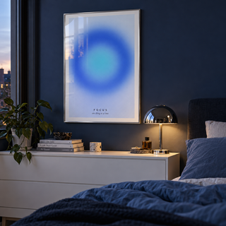 Soft blue gradient print in a bedroom against a blue black wall