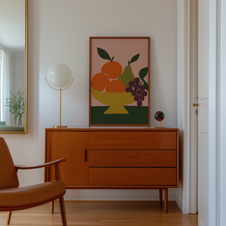 Cut paper oranges, pear and grapes print above a mid century sideboard in a hallway