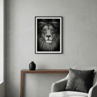 Close-up lion face poster in black and white, framed by thick mane