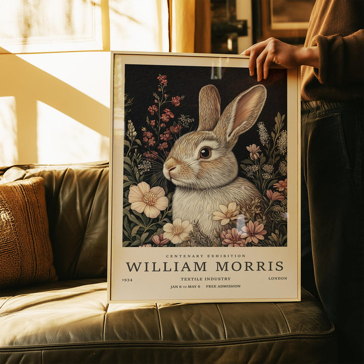 Framed Vintage Rabbit Art of a brown rabbit with flowers held above a leather sofa