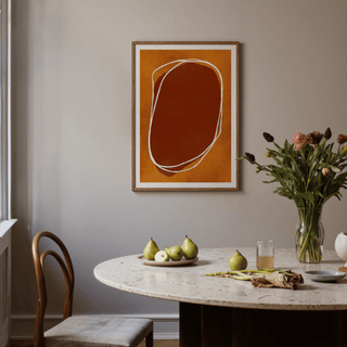 Textured rounded form art print resting on wooden shelf with small plant