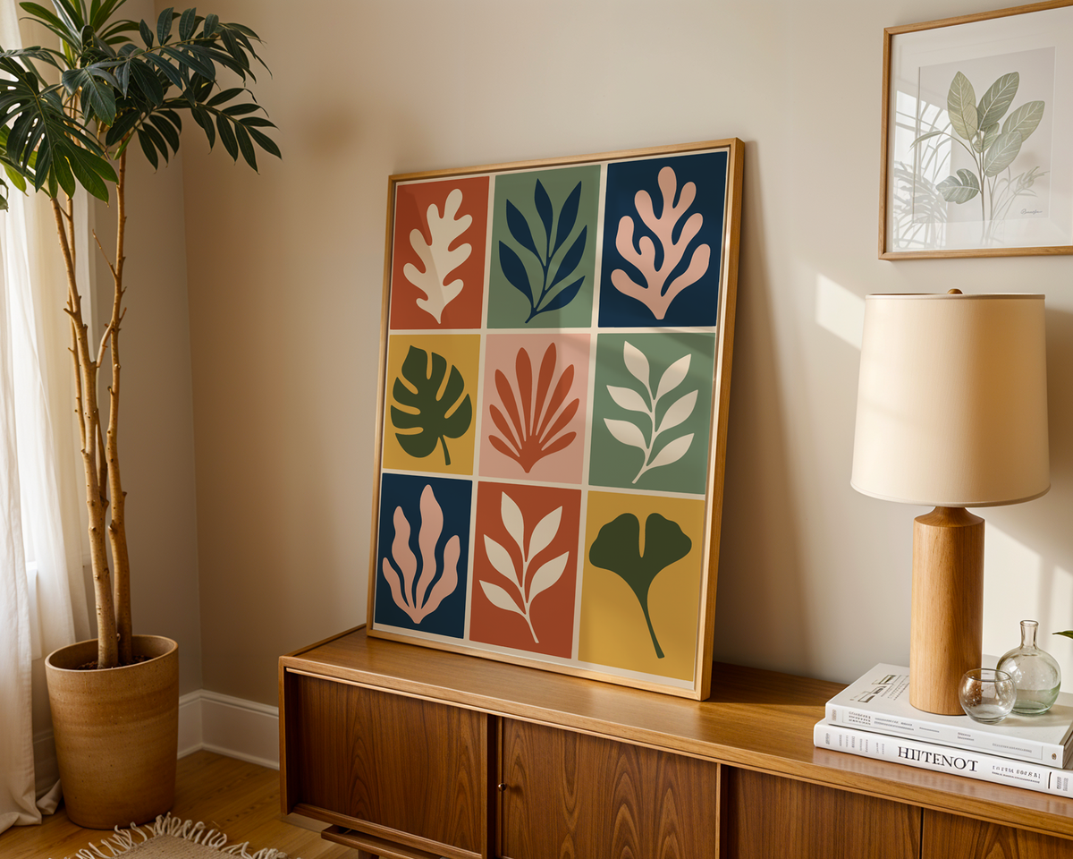 Cut out print of nine leaf tiles leaning on a wooden sideboard in a warm living room