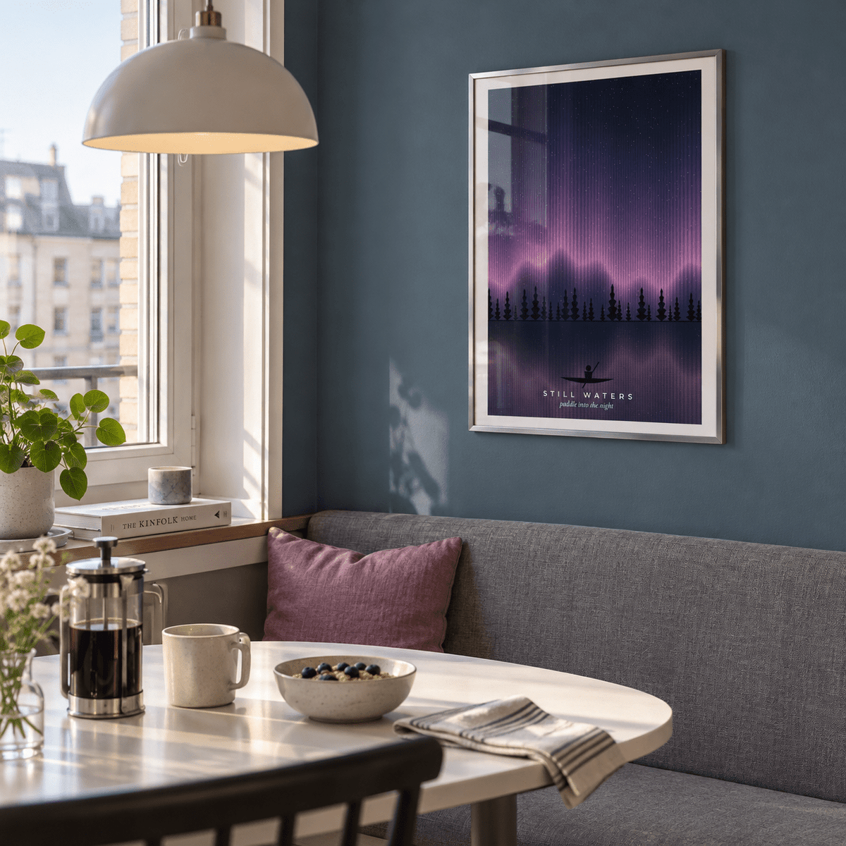 Pink aurora over a lake with a canoe print above a banquette in a breakfast nook
