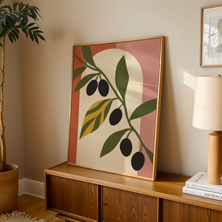 Olive leaf print with black olives leaning on a wooden sideboard in a warm living room
